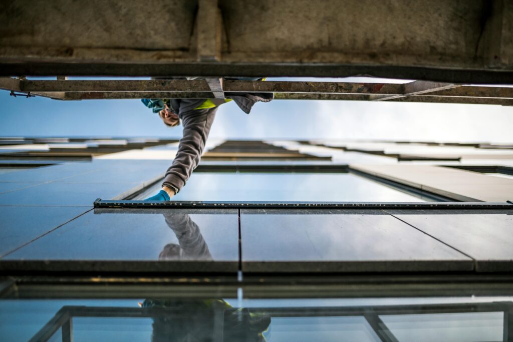 A window cleaner in action on a high-rise building, reflecting modern architecture.